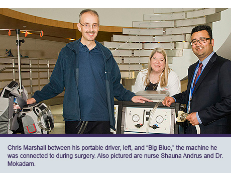 Chris Marshall between his portable driver, left, and “Big Blue,” the machine he was connected to during surgery. Also pictured are nurse Shauna Andrus and Dr. Mokadam.